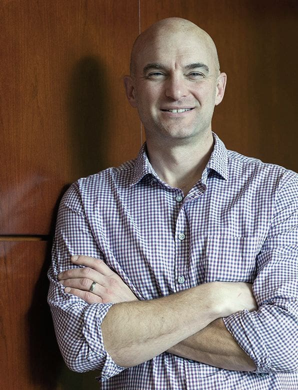 man smiling leaning against the wall